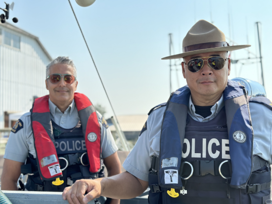 deux policiers dans un bateau, portant des gilets de sauvetage