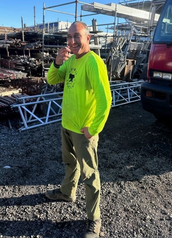 Homme qui porte une chemise à manches longues fluo et un pantalon beige