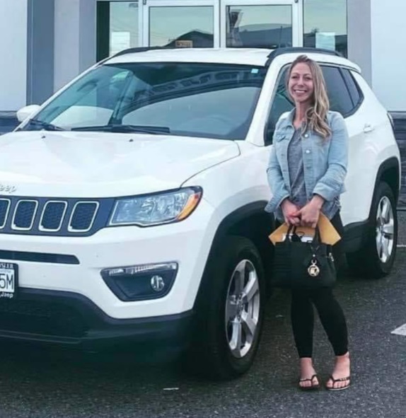 Amber Manthorne standing next to her 2021 white Jeep compass